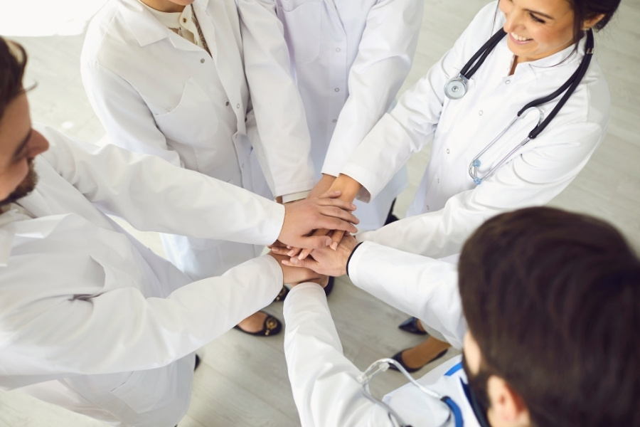 Group of Doctors Joined Hands Together. Medicine Healthcare Clinic Hospital Concept .
